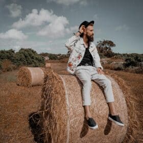 Cottagecore Trend 2025 – Men’s Cozy & Sustainable Style Alt Text: Young man in rustic Cottagecore outfit with natural background, representing Cottagecore trend 2025
